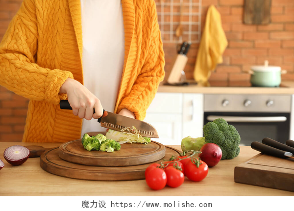 一个穿着黄色毛衣的女人，在厨房备菜女人们在厨房切卷心菜